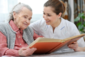 caregiver and old woman scanning the photo album