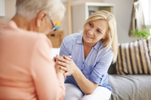 caregiver comforting old woman